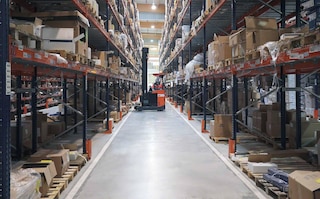 Met behulp van een heftruck worden geretourneerde goederen in de magazijnstellingen geplaatst