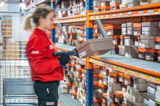 Een magazijnmedewerker verzamelt artikelen met de pick to cart-methode