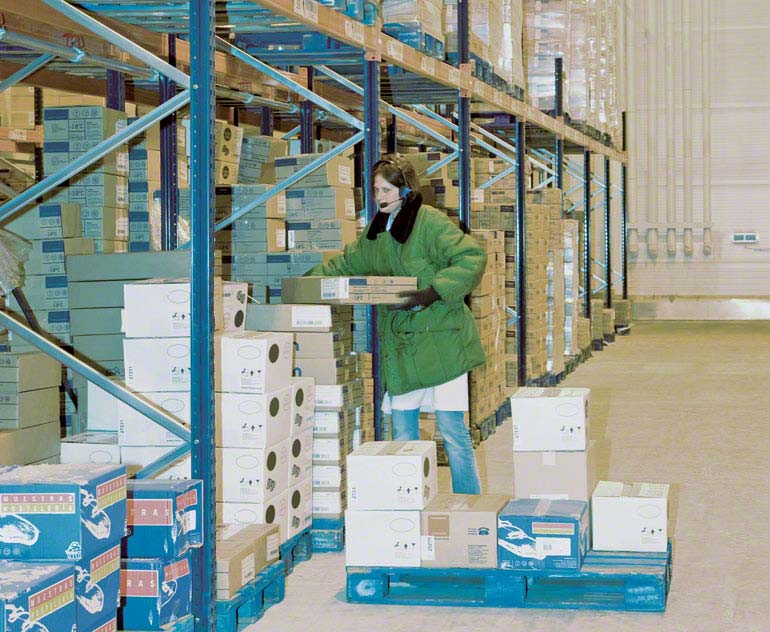 Orderpicking op vloerniveau in een magazijn met palletstellingen