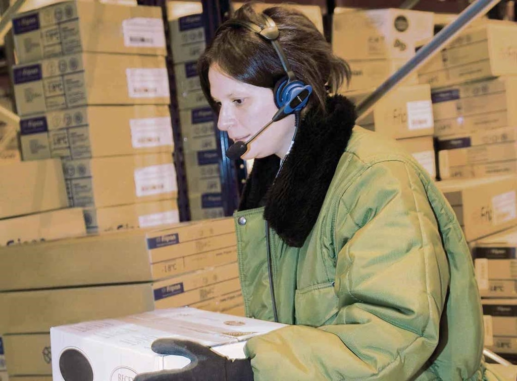 De orderpicker voert zijn werk uit met behulp van een voicepicking systeem De orderpicker voert zijn werk uit met behulp van een voicepicking systeem