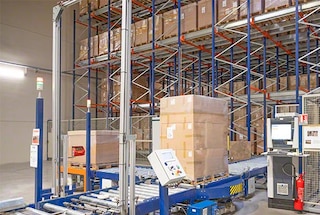 De pallet komt het magazijn binnen via een transportband