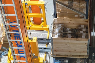 Het uithaalsysteem pakt de pallet op en plaatst deze in de hefbak