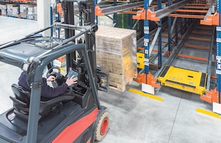 De operator gebruikt een vorkheftruck om de pallet aan de ingang van elk kanaal te plaatsen