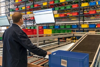 De dozen komen via de transportbanen aan bij het pickstation