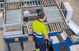 Een transportbaan voor dozen of kratten stroomlijnen de bevoorrading van de pickingstations